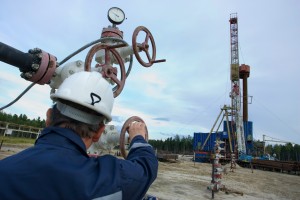 A drilling rig worker. Focus is on the instruments.